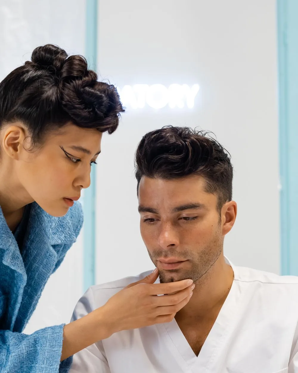 A clinician assessing a patient’s mid-face during a consultation.