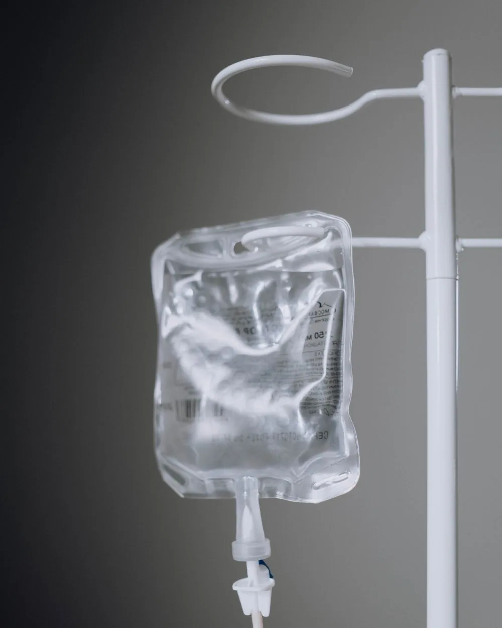 An intravenous infusion bag hanging on a stand.